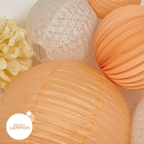 Peach and off-white paper lanterns for nursery decor