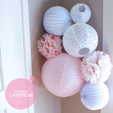 Pink nursery decor with paper lanterns and pompoms