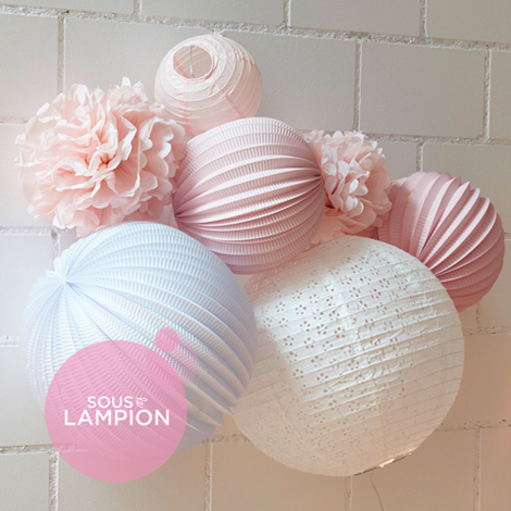 Décoration de chambre de bébé rose et blanche avec des boules papier et des pompons