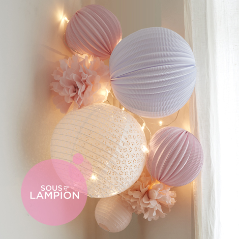 Décoration de chambre de bébé rose et blanche avec des boules papier et des pompons